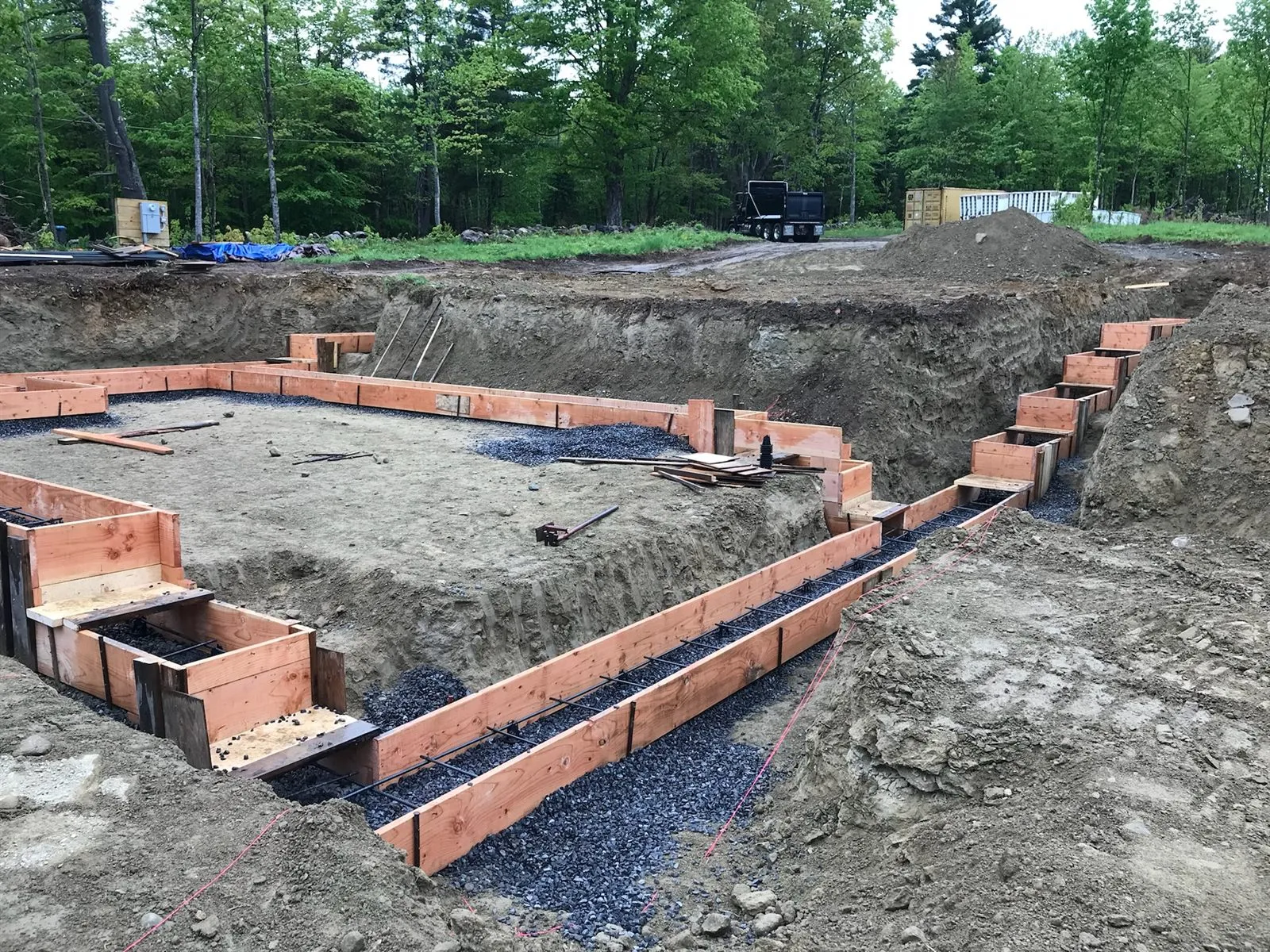 Footing forms with rebar set in the excavated houselot