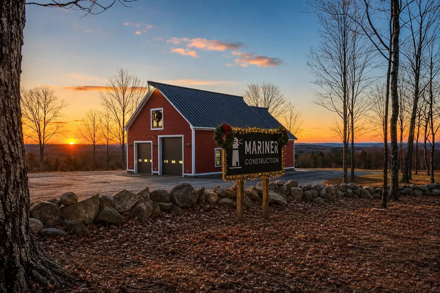 The lighted Mariner Construction sign at sunset, with a red barn behind it